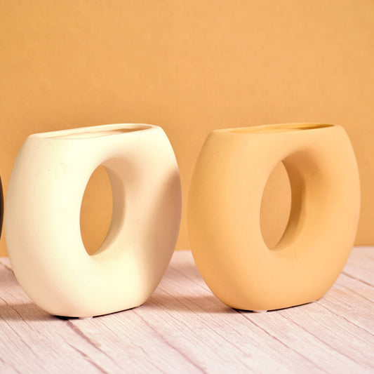 two different coloured half donut vases
