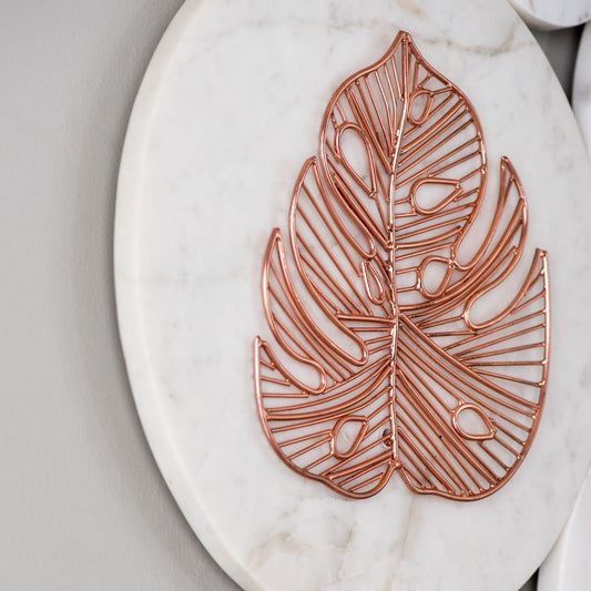 Close up of rose gold metal and white marble wall decor