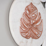 Close up of rose gold metal and white marble wall decor