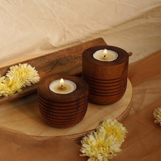 two lit wooden candlestick holders