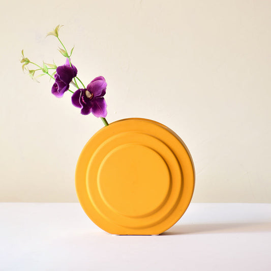 Round contour yellow vase with flowers