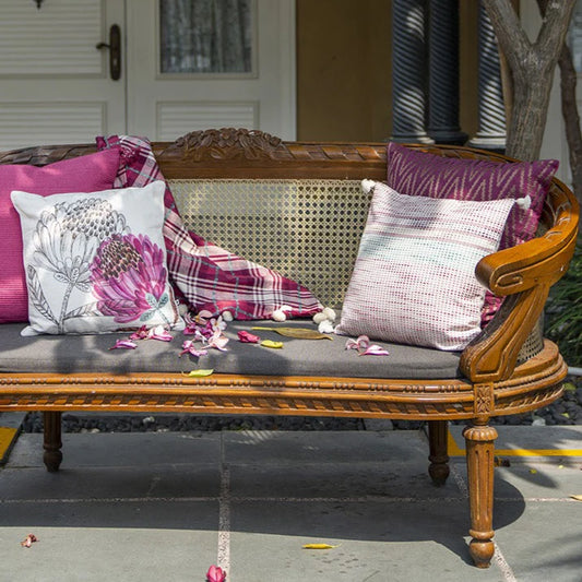 Outdoor cushions with throw on wooden sofa