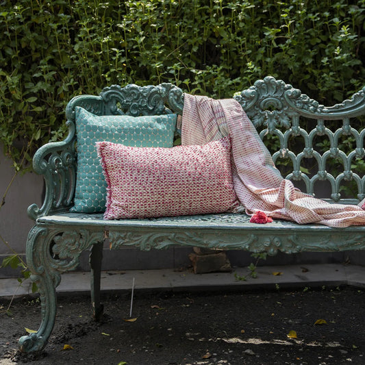 Multicolour cushion and pillow with throw on garden bench