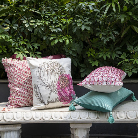 two rectangular pillows and two square cushions on the garden bench