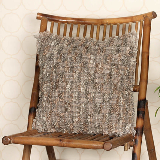 Chocolate colour cushion on wooden chair with fringe