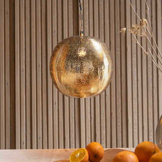 Illuminated golden pendant lamp over table