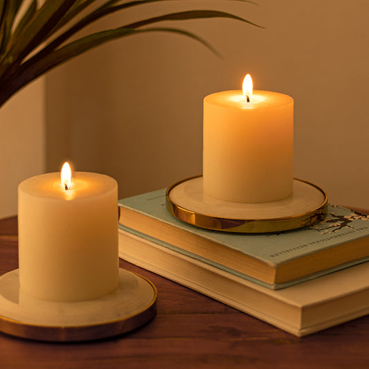 two candles on two marble candle holders