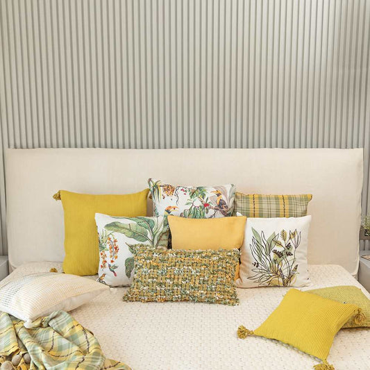 multiple yellow and white cushions on bed
