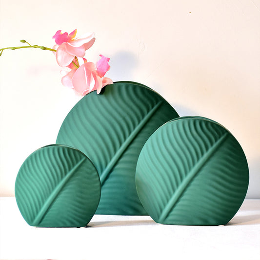 Three sized dark green vases in ceramics
