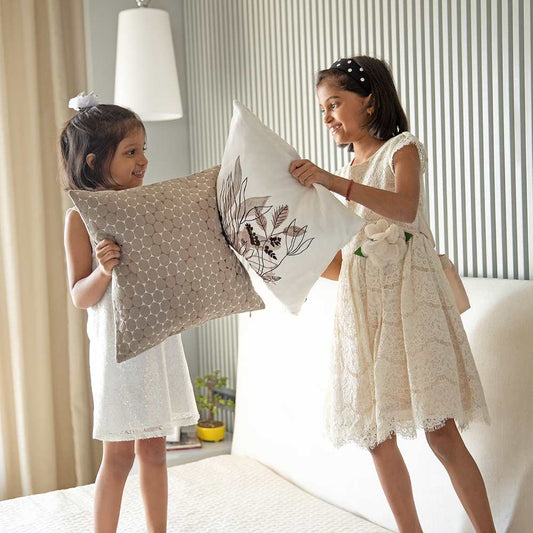 Two young girl playing with cushions