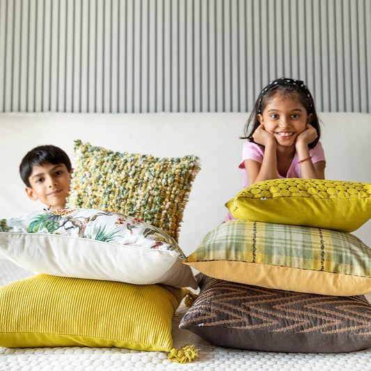 Kids with stack of multiple cushions